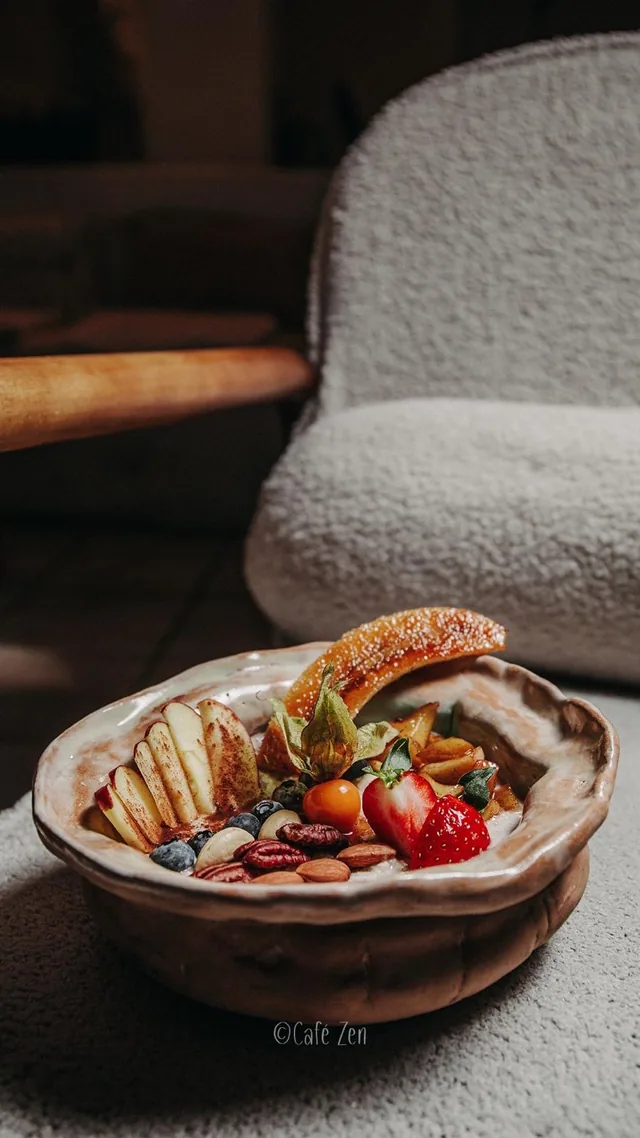 Bowl mit gegrillter Banane, Erdbeeren, Nüssen und Beeren in handgemachter Keramik