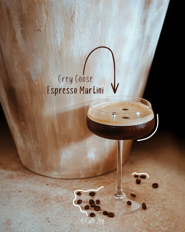 Espresso Martini in einer Coupette, daneben verstreute Kaffeebohnen